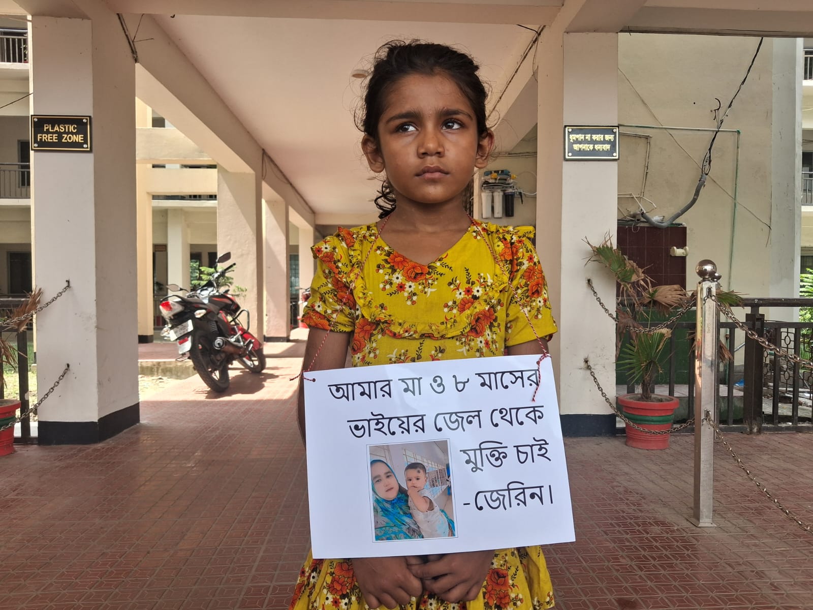 সৎ মায়ের মুক্তির দাবিতে ৮ বছরের শিশু জেরিনের আকুতি, গলায় প্ল্যাকার্ড নিয়ে ইউএনও কার্যালয়ে